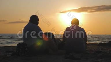 日落时分，一对老年夫妇坐在海滩上，欣赏美丽的<strong>海景</strong>和<strong>海景</strong>